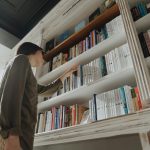 Person touching books on a bookshelf