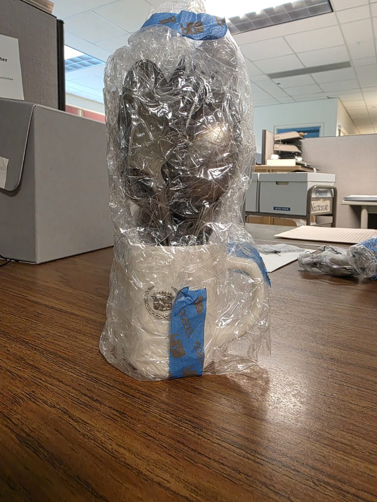 A white mug of silverware bubblewrapped.