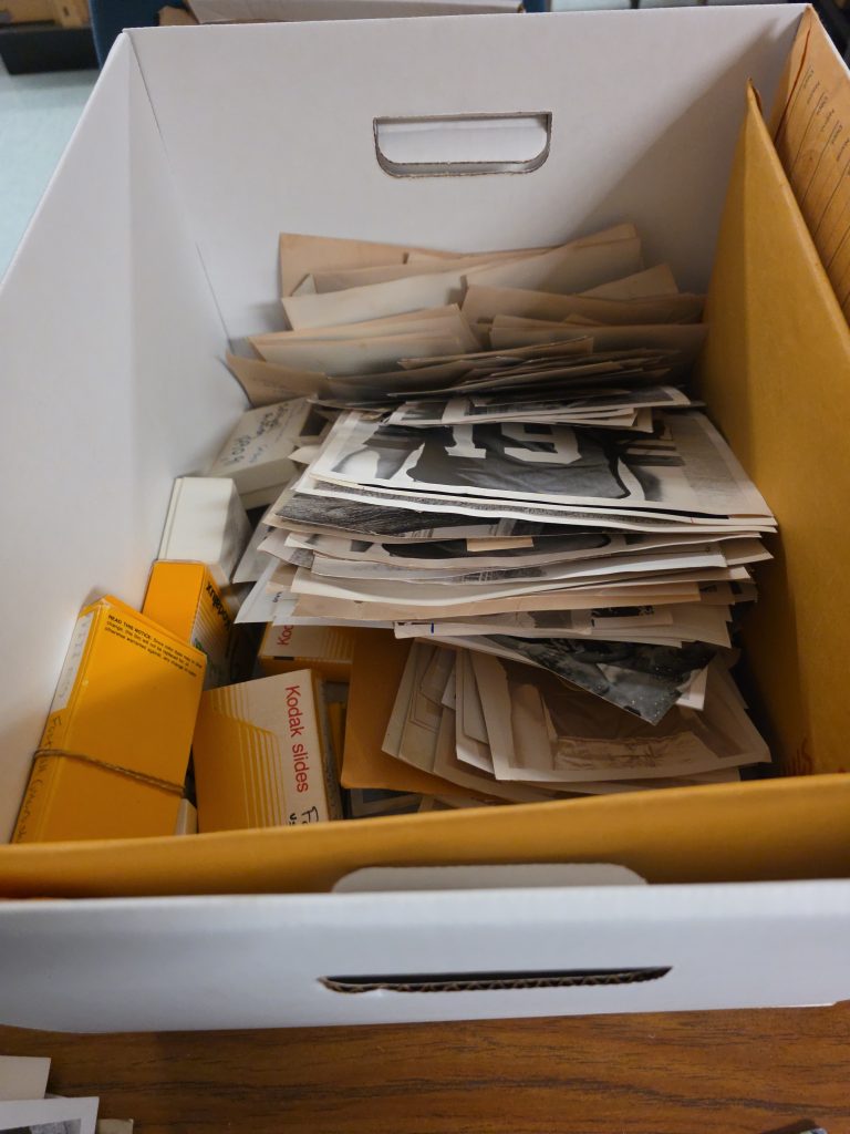 A box of unorganized photographs.