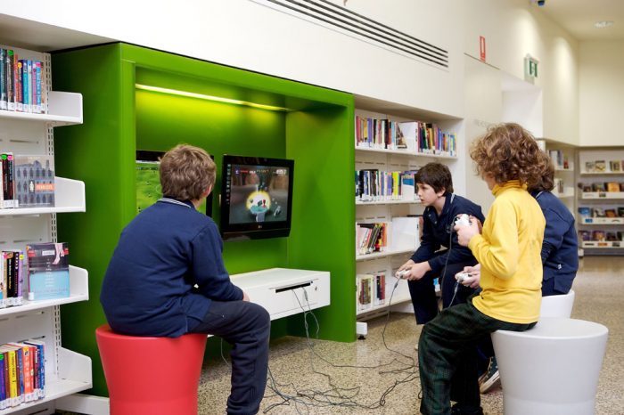 Four children playing video games at the library