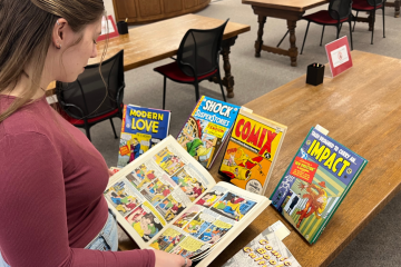 Student flipping through comics in the SDSU SCUA